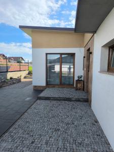 a white house with a brick driveway at Dubrowes cottage in Bobrów
