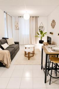 a living room with a couch and a table at Savana Lodge, Wi-Fi, Parking Privé et Calme, Sortie 12 ChanaS in Chanas