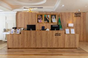 a lobby with a large wooden counter with two computers on it at The Business Hotel By Seafront فندق ذا بيزنس in Jeddah