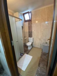 a small bathroom with a toilet and a window at Komilo Homes - Functional Modern Suite in Çamlıhemşin +71 photos