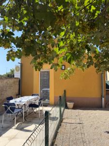a table and chairs in front of a yellow building at Gîte Le lys 2 à 4 personnes in Colmar