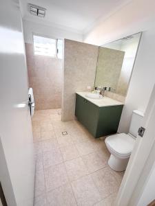 a bathroom with a toilet and a sink and a mirror at The Sierra in Dunsborough