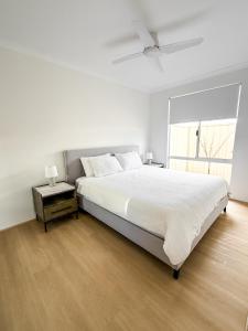 a white bedroom with a large bed and a window at The Sierra in Dunsborough