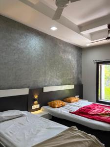 two beds in a room with a wall at Sakkhar Palace in Indore