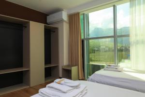 a hotel room with two beds and a large window at Hotel Impex in Peje +43 photos