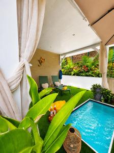 a patio with a swimming pool and green plants at Le SeaZen Lodge in Sainte-Anne +42 photos