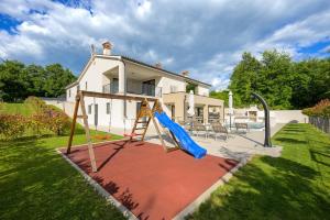 a swing set in a yard in front of a house at Villa Mochi by IstriaLux in Pićan
