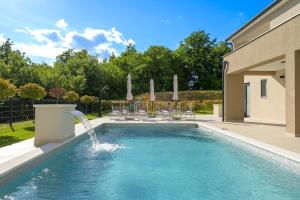 a swimming pool with a water fountain at Villa Mochi by IstriaLux in Pićan