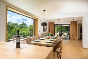a dining room with a table and chairs and a large window at Villa Mochi by IstriaLux in Pićan