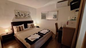 a small bedroom with a bed and a refrigerator at Apartments & Dream Rooms in Niš +142 photos