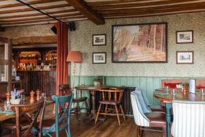 a restaurant with tables and chairs and a painting on the wall at The Bell & Stuart House in Stow on the Wold