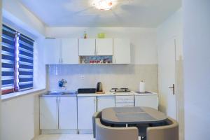 a kitchen with white cabinets and a table and chairs at Una & Lake oasis in Bihać