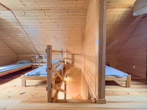 two bunk beds in a room with wooden walls at Domki Wczasowe Mielenko in Mielenko