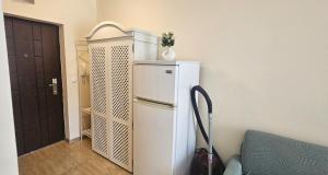 a white refrigerator in a room next to a door at Sun Sea 1 studio sea view in Shkorpilovtsi