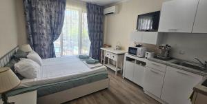 a small room with a bed and a kitchen at Sun Sea 1 studio sea view in Shkorpilovtsi