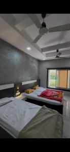 a bedroom with two beds and a window at Sakkhar Palace in Indore +15 photos
