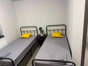 two beds in a room with yellow pillows at Stay Inn in Galaţi