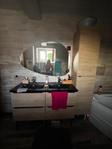 a woman taking a picture of a bathroom with a mirror at Sevchris in Saint-Laurent-de-la-Prée