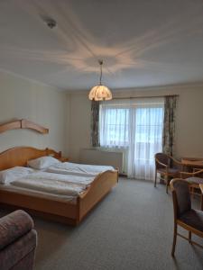 a bedroom with a bed and a chandelier at Hotel-Pension Asingerhof in Schladming