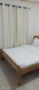 a bed with a wooden frame in a room at 1 bedroom BNB Meru in Meru