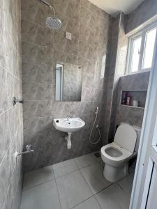 a bathroom with a toilet and a sink at Peace Nest bamburi in Mombasa +13 photos