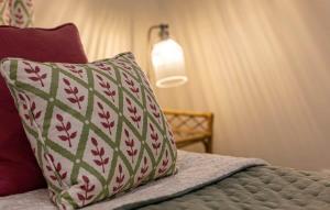 a bed with a pillow and a lamp on it at Converted Barn - Romantic Countryside Escape in Cupar