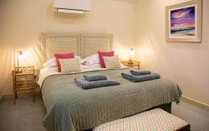 a bedroom with a large bed with two pillows on it at Converted Barn - Romantic Countryside Escape in Cupar