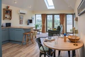 a kitchen and living room with a table and chairs at Converted Barn - Romantic Countryside Escape in Cupar