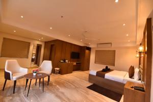 a hotel room with a bed and a table and chairs at Eennra Ssubarna in Baharampur