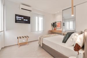 a bedroom with a bed and a tv on the wall at Elan Suites Preveza in Preveza