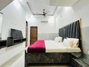 a bedroom with a large bed and a tv at Hotel Royal Residency - Laxmi Nagar in New Delhi