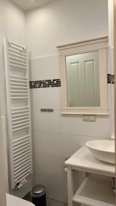 a white bathroom with a sink and a mirror at Alte Büdnerei - DZ "Bambus" in Brunshaupten