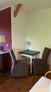 a room with two chairs and a table with a lamp at Alte Büdnerei - DZ "Bambus" in Brunshaupten