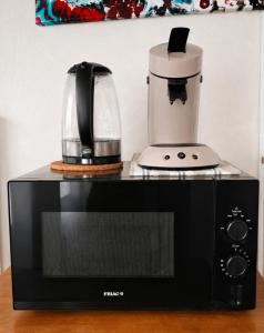 a coffee maker sitting on top of a microwave at Les Mésanges Bleu in Malmedy