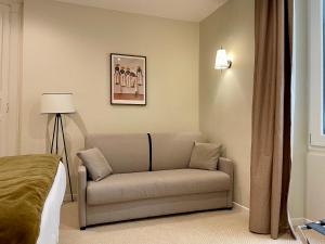 a living room with a couch and a lamp at Hôtel du Théâtre - Hypercentre - Climatisé in Bordeaux +43 photos