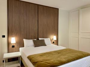 a bedroom with a large bed with a wooden headboard at Hôtel du Théâtre - Hypercentre - Climatisé in Bordeaux