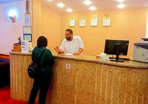 a man talking to a woman at a reception desk at DaVinCi hotel in Hurghada
