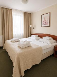 ein Hotelzimmer mit zwei Betten, auf denen Handtücher liegen in der Unterkunft Arena Hotel Spa & Wellness in Tychy