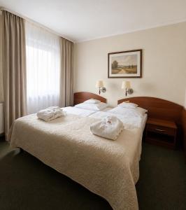 ein Hotelzimmer mit zwei weißen Handtüchern auf einem Bett in der Unterkunft Arena Hotel Spa & Wellness in Tychy + 64 Fotos
