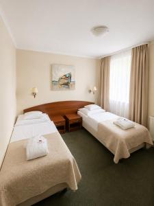 ein Hotelzimmer mit zwei Betten und einem Fenster in der Unterkunft Arena Hotel Spa & Wellness in Tychy