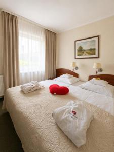 ein Hotelzimmer mit zwei Betten, auf denen Handtücher liegen in der Unterkunft Arena Hotel Spa & Wellness in Tychy