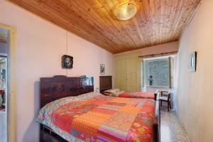 a bedroom with two beds and a wooden ceiling at Casa Fenera in Valduggia
