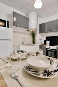 a kitchen with a table with a bowl and plates on it at Savana Lodge, Wi-Fi, Parking Privé et Calme, Sortie 12 ChanaS in Chanas +17 photos