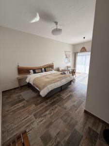 a bedroom with a bed and a wooden floor at Berg & Baai guesthouse in Plettenberg Bay