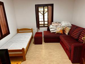 a living room with a couch and a bed at Weekend House in Vrelo in Jelovica