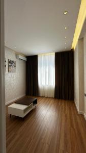 a large room with a bed and a large window at Apt Elite in Khujand
