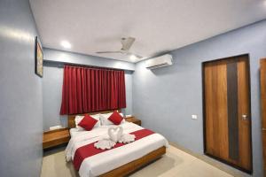 a bedroom with a bed with two towels on it at Hotel Happinex Inn in Surat