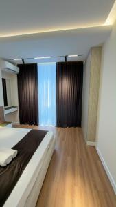 a bedroom with a large bed and wooden floors at Apt Elite in Khujand