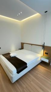 a bedroom with a large white bed with a black blanket at Apt Elite in Khujand