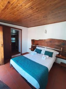 a bedroom with a large bed with a wooden headboard at Refugio de São Luis in São Luis +30 photos